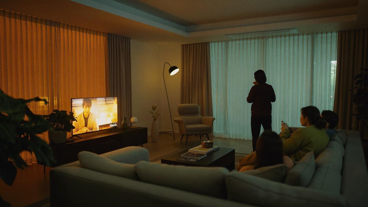 Família relaxando em sala aconchegante com iluminação automatizada